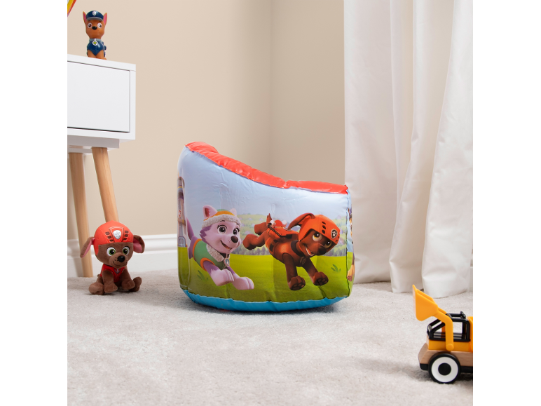 Inflatable children's armchair with cartoon characters, plush toys, and a toy car on a rug.