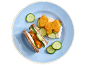 Open sandwiches with animal-shaped nuggets, sauce, and cucumbers on a blue plate.