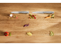 Two kitchen knives with fresh, chopped vegetables on a wooden table.