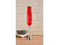 Red hand blender with the numbers '1973' on a wooden surface with a bowl.