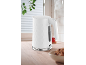 White electric kettle with a hexagonal pattern on a wooden countertop