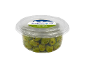 Green Nocellara olives with rosemary and thyme in a clear container.
