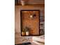 Cork board with keys, plants, and hooks on a wooden table.