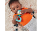 Baby lying on a rug, playing with a squirrel-shaped teether.