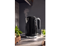 Black kettle with steam, marked '1973', in a modern kitchen.