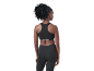Woman in black sports bra and black leggings, rear view.