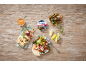 Greek-style stuffed vine leaves with rice, salad, bread, and dip on a wooden table.