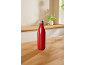 Red insulated bottle on a wooden kitchen surface.