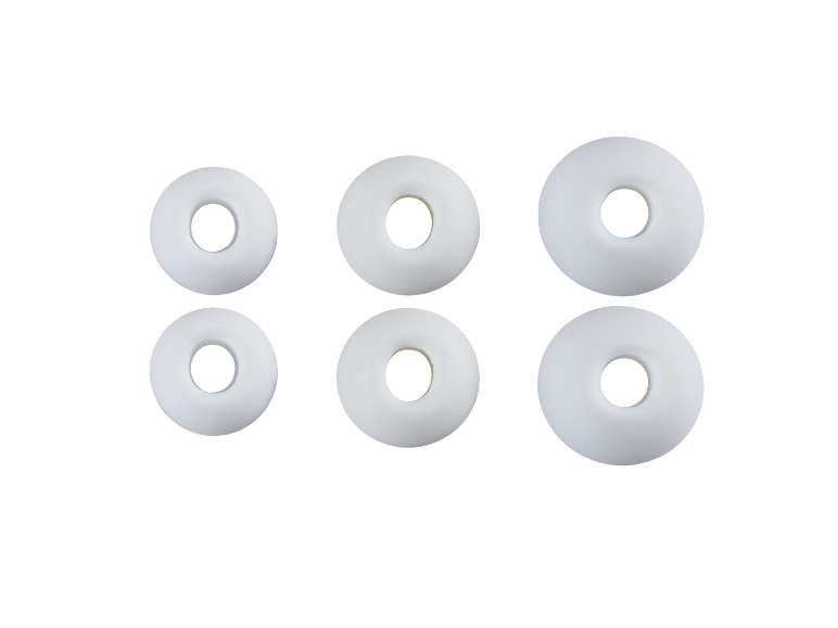 Six white, round mint candies with a hole in the middle, on a black background.