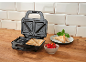Sandwich maker with prepared sandwiches, tomatoes, and basil.