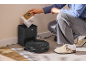 Person changing the dust bag in a self-emptying station for a robot vacuum cleaner.