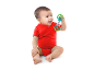 Baby in red bodysuit playing with a colorful rattle.