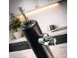 Black and chrome beverage dispenser on a marble kitchen countertop.
