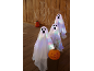 Glowing ghosts and Halloween pumpkins on a wooden background