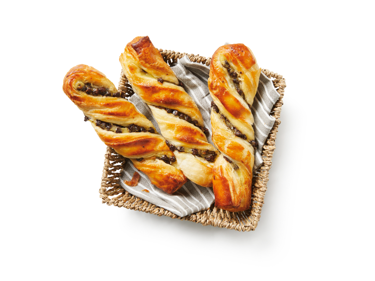 Chocolate twists in a wicker basket with a cloth.