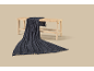 Dark blue knitted throw draped over a light wooden bench with a woven seat.