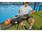 Man with padel racket and sports bag on a court bench.