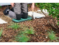 Garden kneeling pad and hand trowel for planting in mulch.