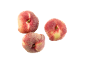Three flat peaches with red and yellow skin on a black background.