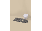 Two striped bath mats in front of a wall-mounted toilet.