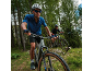 Two cyclists on mountain bikes riding on a forest trail.