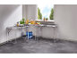 L-shaped kitchen counter with utensils, plates, and water bottles.