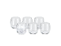 Set of six clear stemless glasses, one filled with ice and sparkling water.