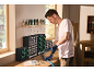 Man assembling a hose on a workbench with drawer organizers and screwdrivers.