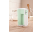 Mint green hand mixer on a wooden countertop with baking ingredients.