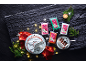 Christmas cakes and colorful fondant icing on a dark slate background with festive lights.