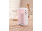 Pink hand mixer on a wooden countertop with a bowl of flour and milk.