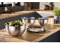Stainless steel mixing bowls with lids, one filled with salad, on a kitchen counter.