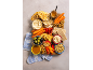 Snack board with hummus, carrots, crackers, nuts, and fruit