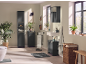 Modern bathroom with black cabinets, sink, mirror, and plants.