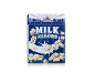 Cereal box with 'Milk Pillows' and 'with Milk Crème Filling' text, showing cereal pieces and milk splash.