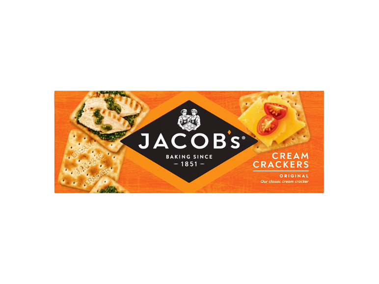 Packaging of cream crackers topped with chicken pesto and cheese with tomatoes.