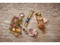 Salami and cheese platter with bread, salad, and a roll of baking paper on a wooden table.