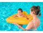 Smiling baby in a yellow pool float with a woman in the water.