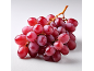 A vibrant bunch of red grapes on a white surface.