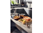 Copper cookware with a pan of salmon, rice, and lemon on a kitchen counter.