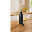 Black water bottle with cap next to a cup of tea with lemon in a kitchen.
