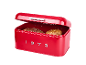 Red bread bin with two loaves of bread, open lid, and the inscription '1973'.