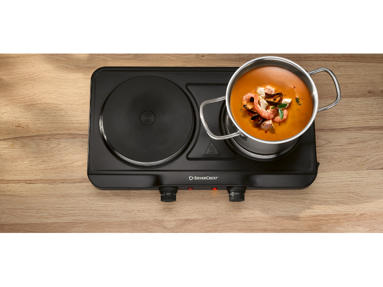 Double hot plate with a pot of seafood soup on it.