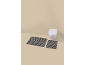 Two striped bath mats in front of a wall-mounted toilet.