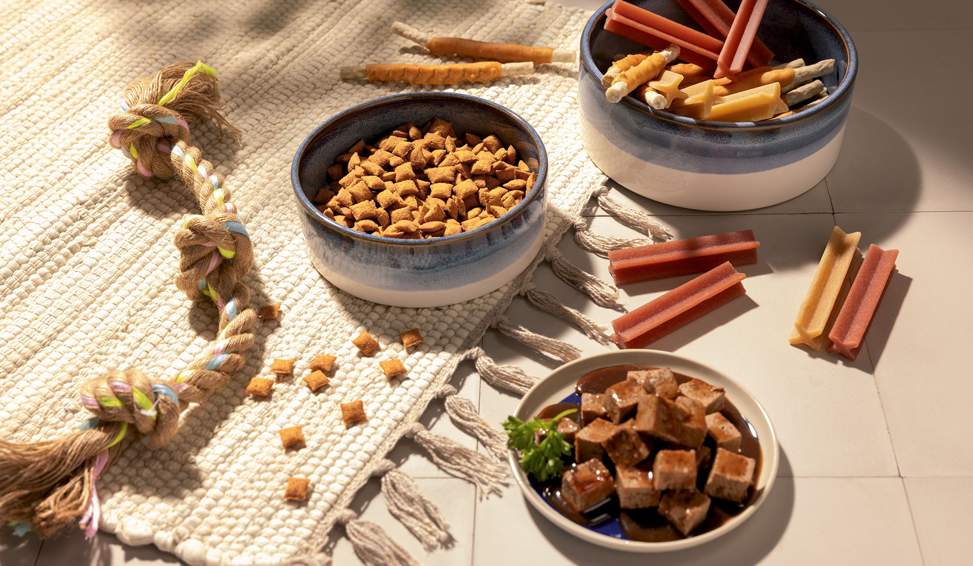 Assorted pet food and treats, including dry kibble, wet food, and chew sticks.
