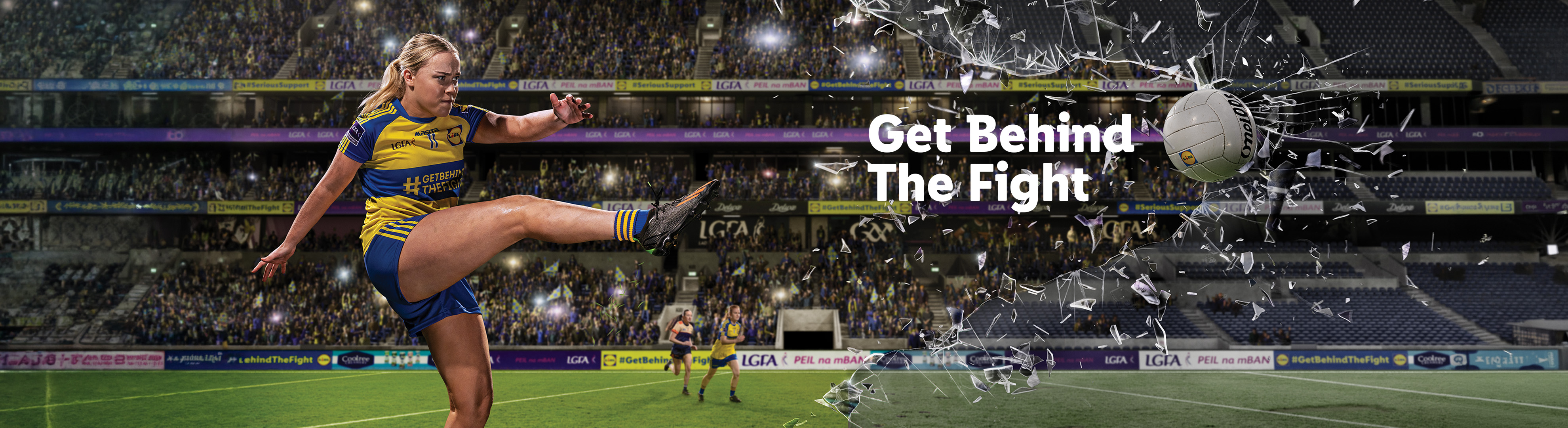 Female athlete kicking a Gaelic football through shattered glass, with text 'Get Behind The Fight'.