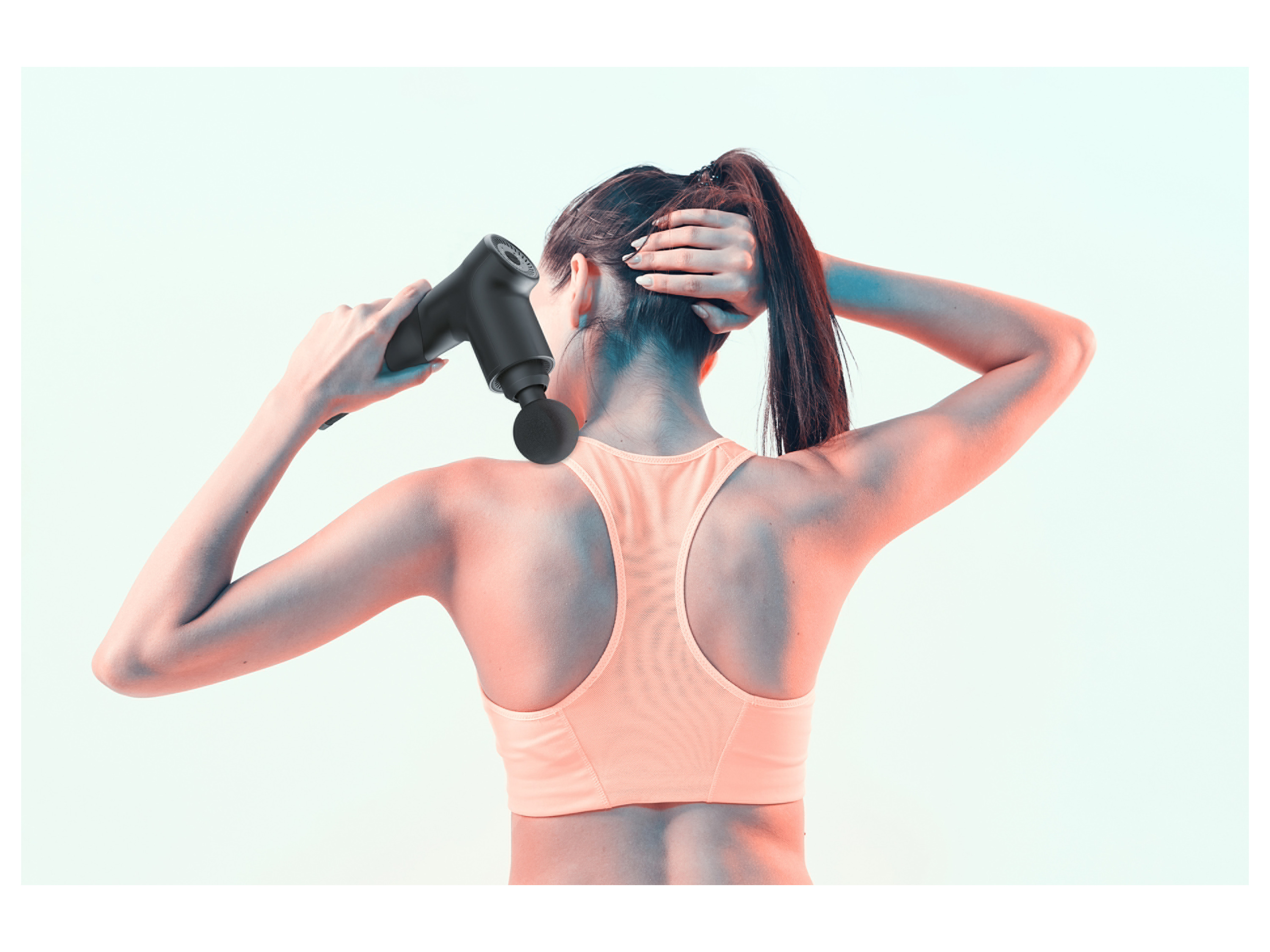 A woman uses a black massage gun on her neck and shoulder.