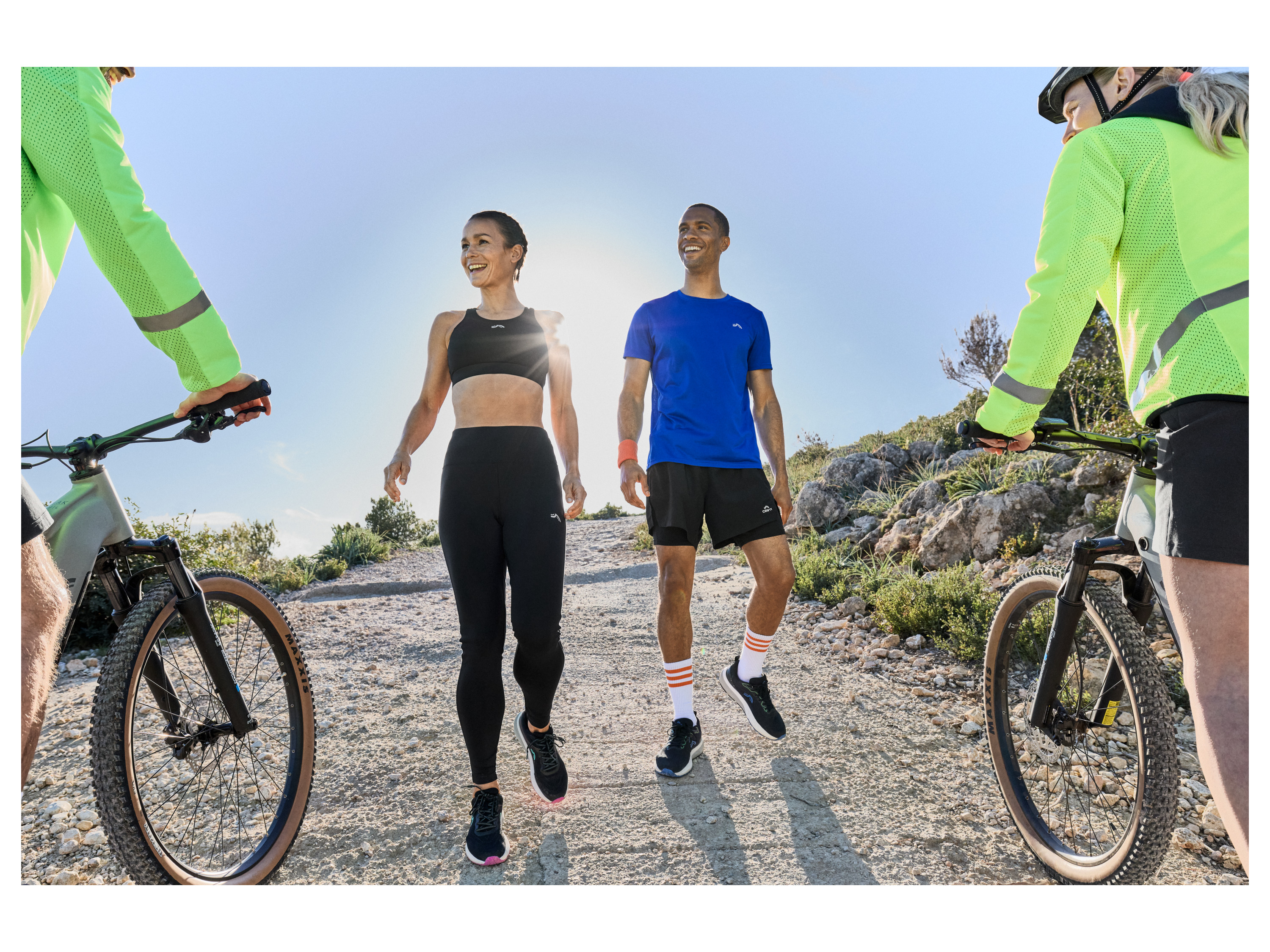 Three adults enjoy an active outdoor lifestyle wearing Karrimor sportswear while cycling and running.