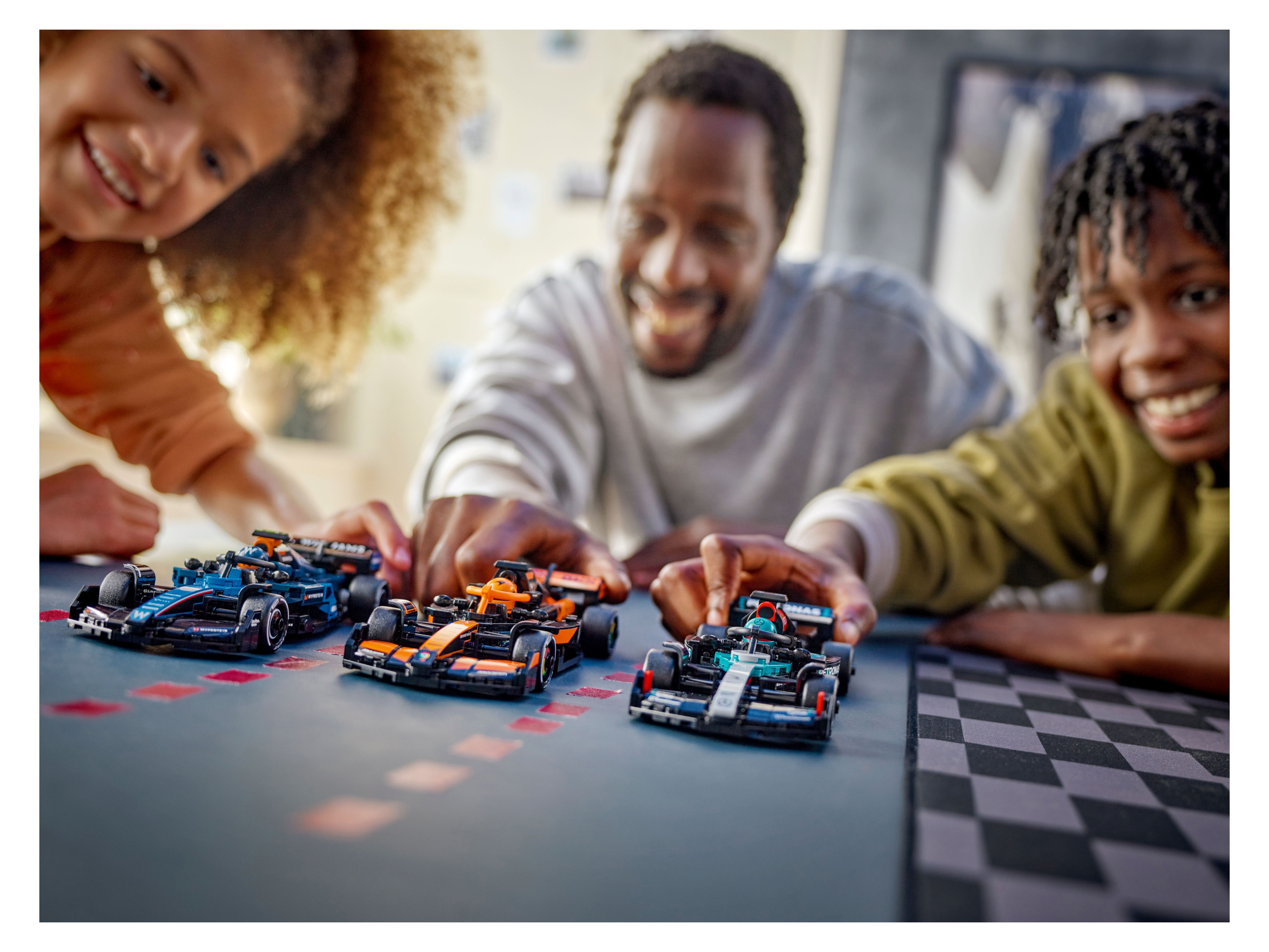 Three children play with LEGO Speed Champions Formula 1 race cars.