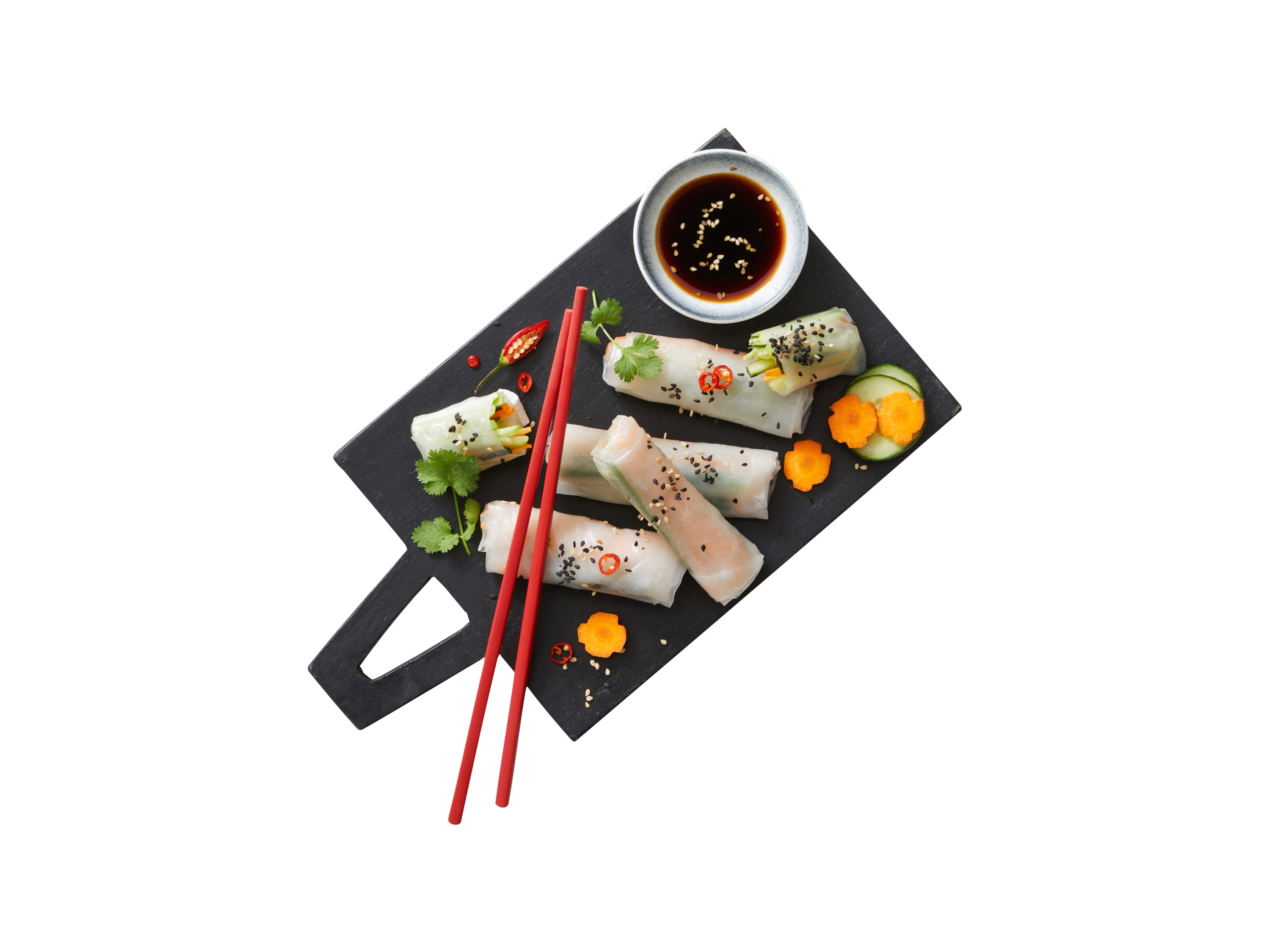 Fresh spring rolls with dipping sauce and chopsticks on a black slate.